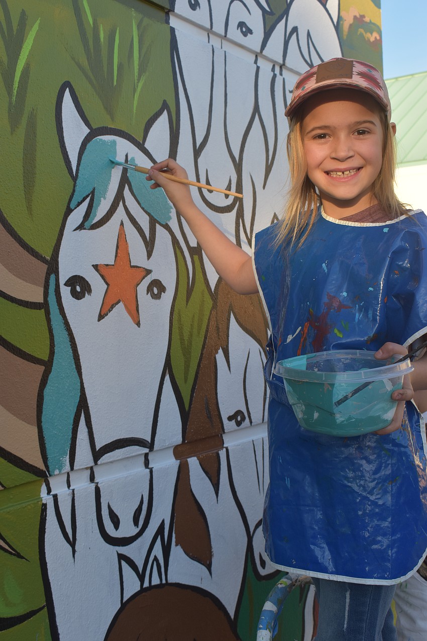Chloe Erickson, a second grader at Myakka City Elementary, didn't let her nervousness of the paint dripping down stop her from painting the mural.
