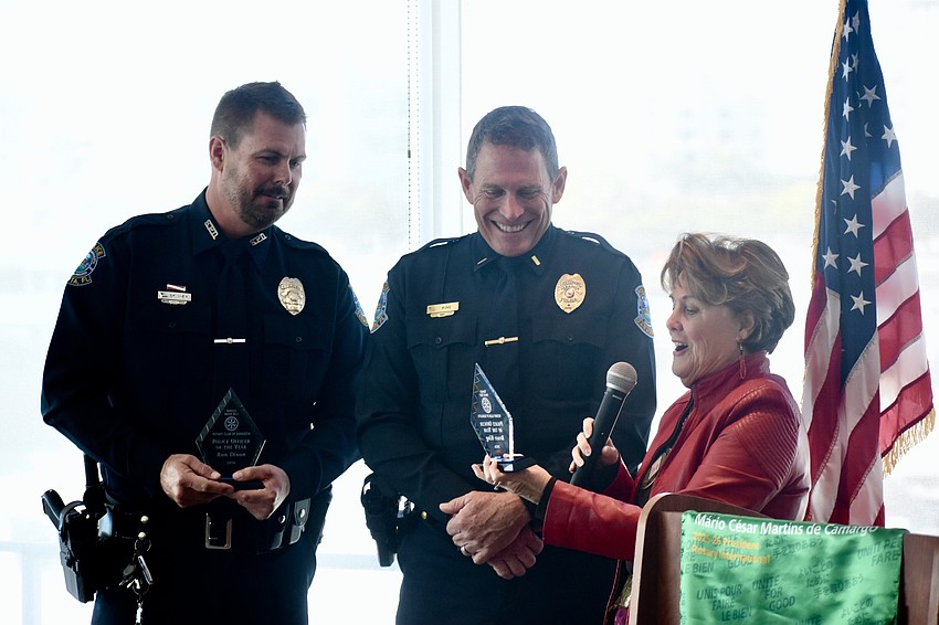 Officer Michael Skinner (representing honoree Ron Dixon) of Sarasota Police Department, and Lieutenant Bruce King of Sarasota Police Department accept the award from Rotary Club president Pam Akins.