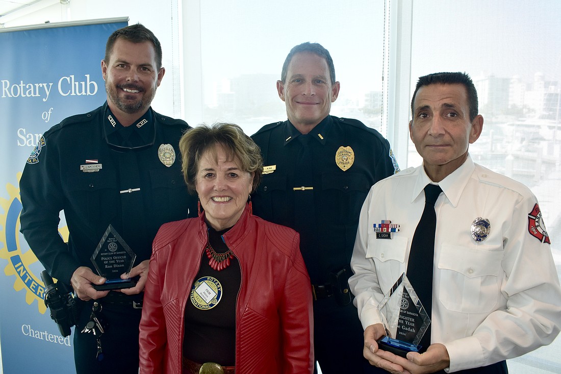 Officer Michael Skinner (representing honoree Ron Dixon) of the Sarasota Police Department; Rotary Club president Pam Akins; Lieutenant Bruce King of the Sarasota Police Department; and honoree Gabe Gadah of Sarasota County Fire Department gather together.