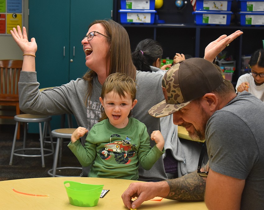 Sabrina Zadai, Brody Zadai, 2, and Patrick Zadai play a game of Book Bingo at CommUNITY Night.