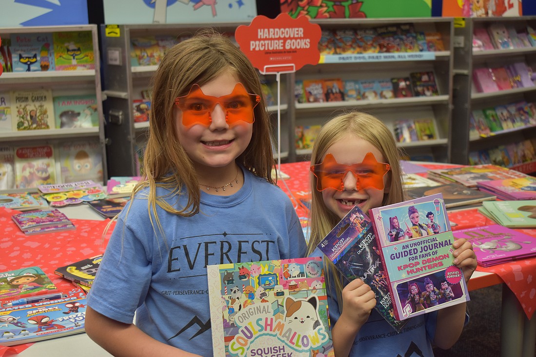 Myakka City Elementary first graders Delanee Verly and Emma Kelly check out the wide variety of books for sale during the CommUNITY Night.