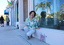 Local artist Joan Love points out "Tiny Door" installation hidden in plain sight outside the former Apricot Lane Boutique on St. Armands Circle. Her most recent installation can be found outside Gauthier Salon & Wellness Spa.