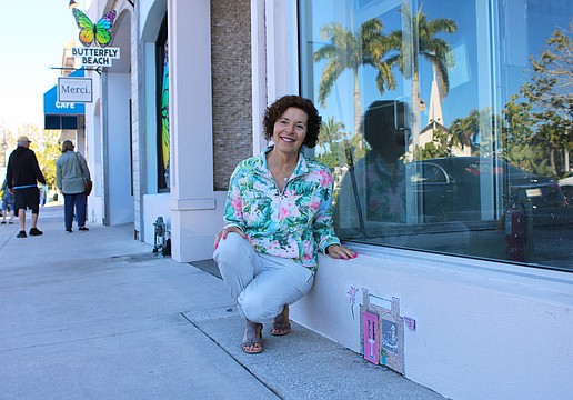 Local artist Joan Love points out "Tiny Door" installation hidden in plain sight outside the former Apricot Lane Boutique on St. Armands Circle. Her most recent installation can be found outside Gauthier Salon & Wellness Spa.