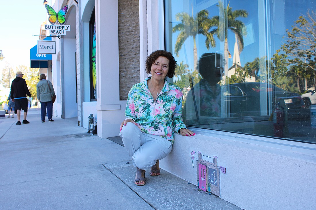 Local artist Joan Love points out "Tiny Door" installation hidden in plain sight outside the former Apricot Lane Boutique on St. Armands Circle. Her most recent installation can be found outside Gauthier Salon & Wellness Spa.