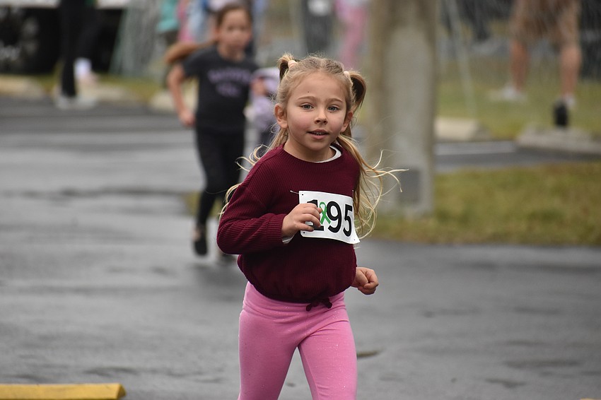 Madison Desiderato, a past student of Kelly Miles, runs as part of the Miles for the Miles Family Cozy Cocoa Dash on Jan. 31.