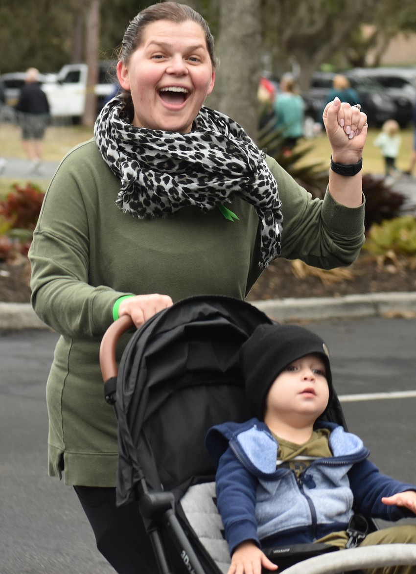 Sarah Reedy runs with her 2-year-old son Warren during the Miles for the Miles Family Cozy Cocoa Dash.