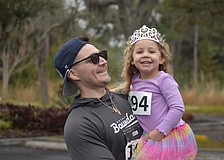 Dillon Desiderato and daughter Nora Desiderato share a smile during the Miles for the Miles Family Cozy Cocoa Dash fundraiser at All God's Children Preschool on Jan. 31.