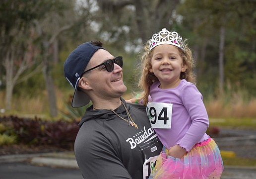 Dillon Desiderato and daughter Nora Desiderato share a smile during the Miles for the Miles Family Cozy Cocoa Dash fundraiser at All God's Children Preschool on Jan. 31.