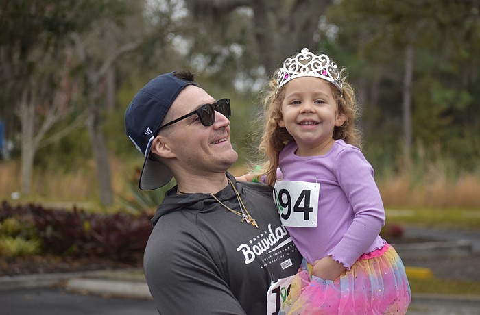 Dillon Desiderato and daughter Nora Desiderato share a smile during the Miles for the Miles Family Cozy Cocoa Dash fundraiser at All God's Children Preschool on Jan. 31.