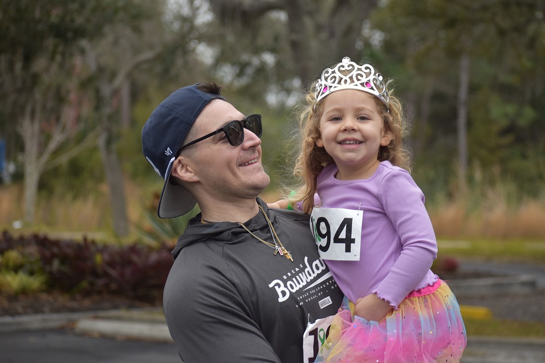 Dillon Desiderato and daughter Nora Desiderato share a smile during the Miles for the Miles Family Cozy Cocoa Dash fundraiser at All God's Children Preschool on Jan. 31.