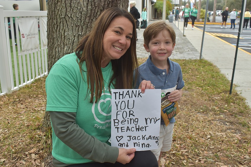 Kelly Miles receives a sign from 5-year-old Jack Verasco thanking her for being his teacher two years after their year of learning and growing together.