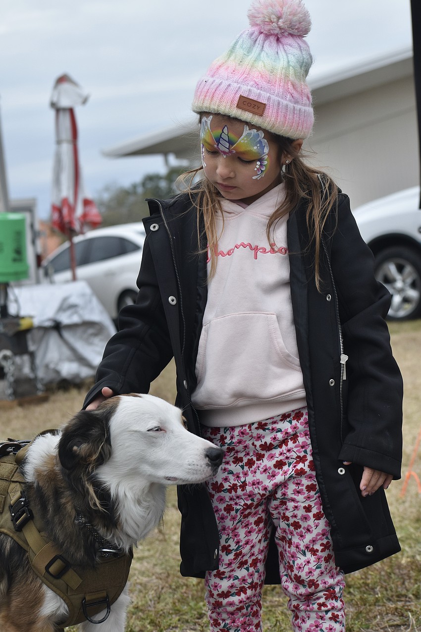 James Timblin's retired service dog Bella, a Collie and Whippet mix who performs at various events, meets Bonnie Pickett, 5.