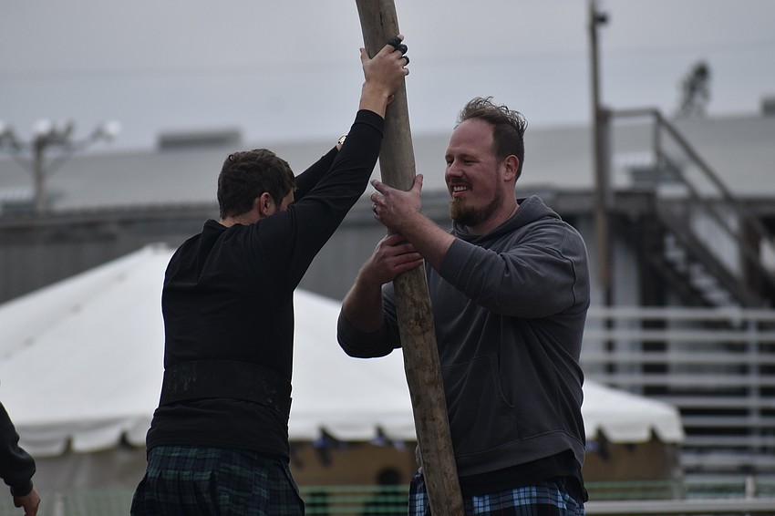 Jason Richards of Ocala hands a caber off to Cameron Gadway of Palm Harbor.