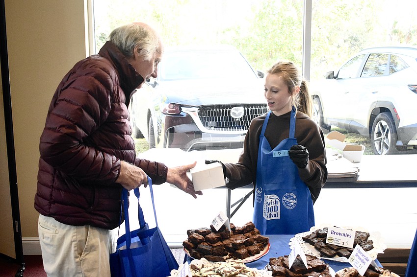 Marty Richmond accepts a package from Holly Gersh, 13.