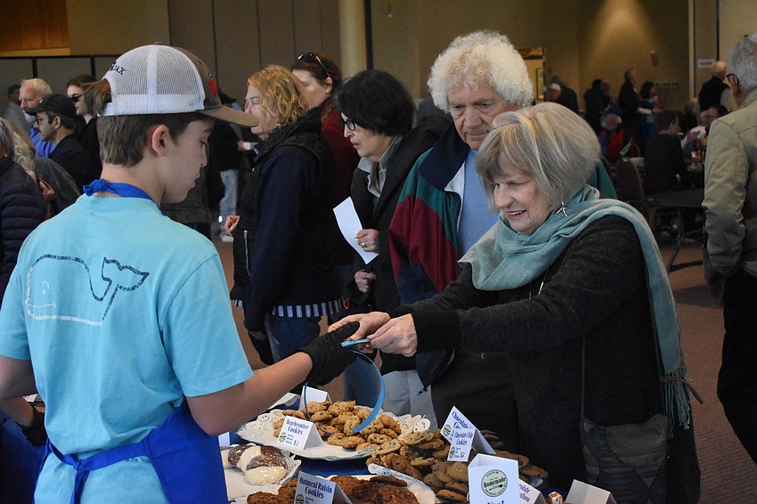 Skate Segal, 14, accepts tickets from Charlie and Eileen Miller.