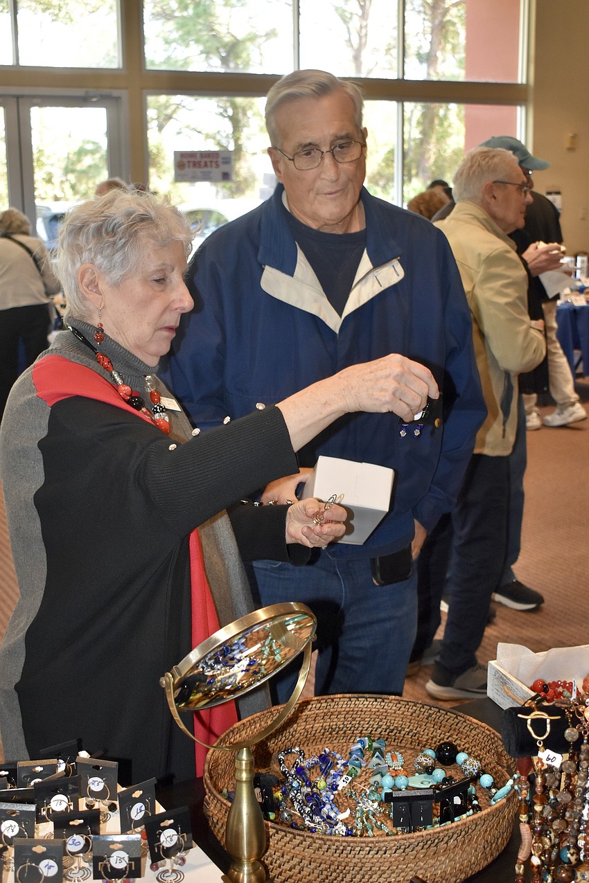 Karen Witte showcases jewelry to Howard Polivy.
