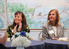 Ann-Marie Thompson and Cheryl Mulherin, attendees at the St. Mary, Star of the Sea, Catholic Church Women's Guild new members luncheon on Jan. 29, applaud the soon-to-be-outgoing board members.