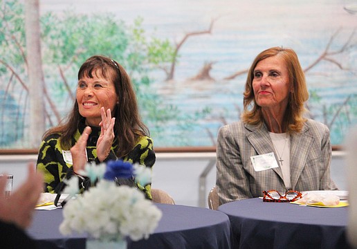 Ann-Marie Thompson and Cheryl Mulherin, attendees at the St. Mary, Star of the Sea, Catholic Church Women's Guild new members luncheon on Jan. 29, applaud the soon-to-be-outgoing board members.