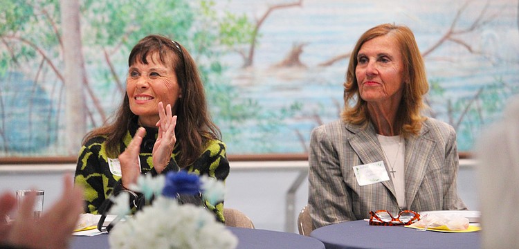 Ann-Marie Thompson and Cheryl Mulherin, attendees at the St. Mary, Star of the Sea, Catholic Church Women's Guild new members luncheon on Jan. 29, applaud the soon-to-be-outgoing board members.