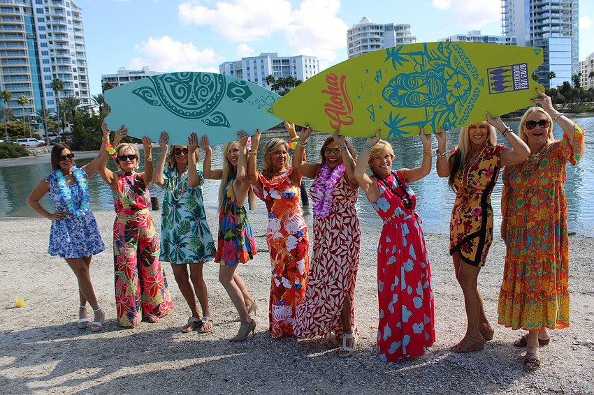 Sisterhood for Good's Stephanie Soffes, Patti Good, Samina Morrow, Karen Medford, Lori Augustyniak, Nikki Pelier-Simon, Angela Massaro-Fain, Allison Adams and Glo Reber bring the boards to Tropical Escape.