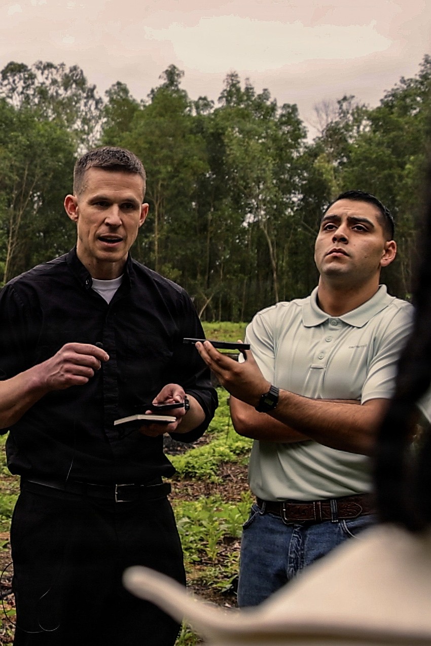 Lieutenant Commander Luke Dundon, 31st Marine Expeditionary Unit chaplain, and Petty Officer Second Class Esteban Chavarry, the unit's religious program specialist, engage with Capt. George Phillips as he tells his story.