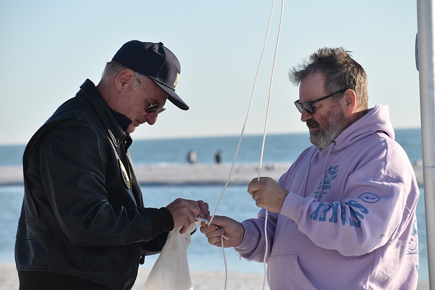 Thomas Modly and Wayne Bundy prepare the flags.