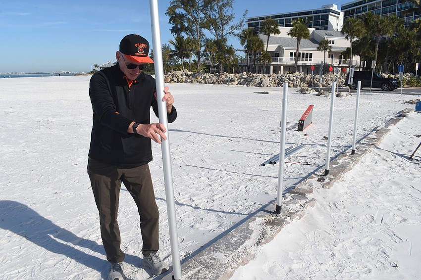 Tom Modly places a flagpole into the pier.