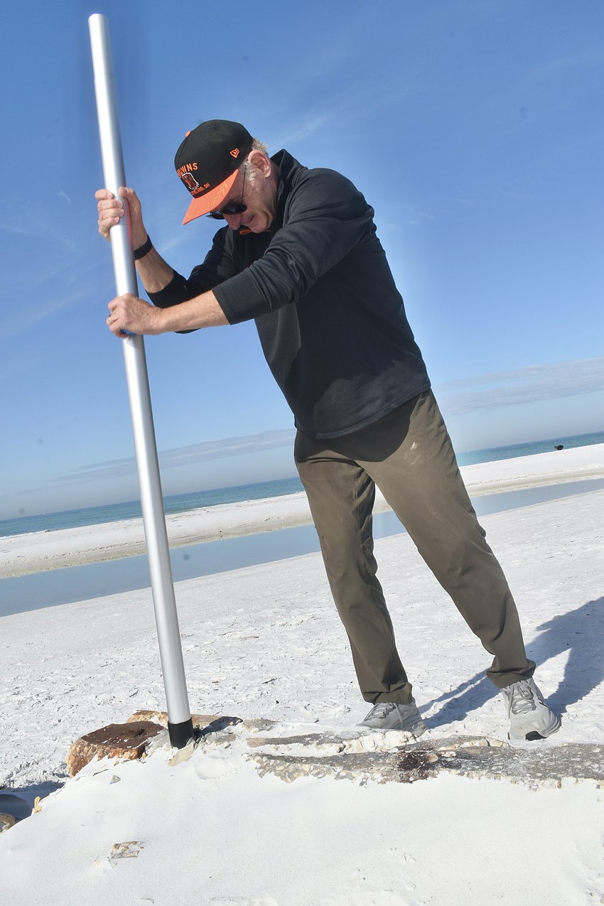 Thomas Modly places a flagpole in the pier.