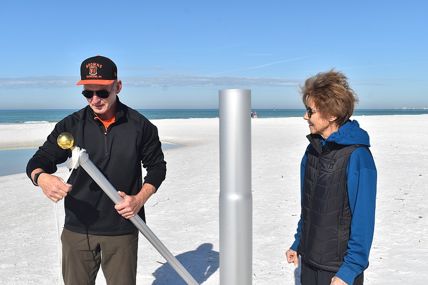 Thomas and Robyn Modly install the flagpoles.