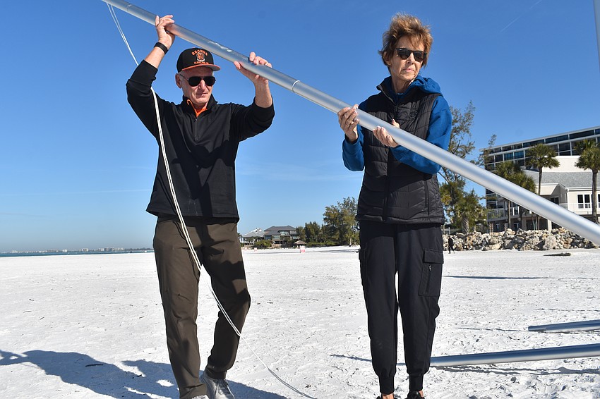Thomas and Robyn Modly place a flagpole on the pier.