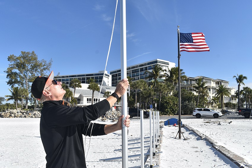 Thomas Modly installs a flagpole on the pier.