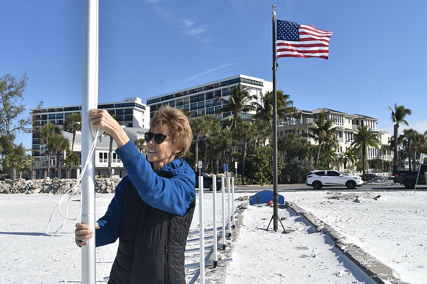 Robyn Modly adjusts the rope on a flagpole.