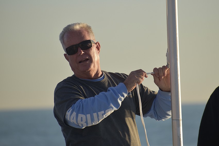 Andy Bass raises the flag of the Marine Corps.