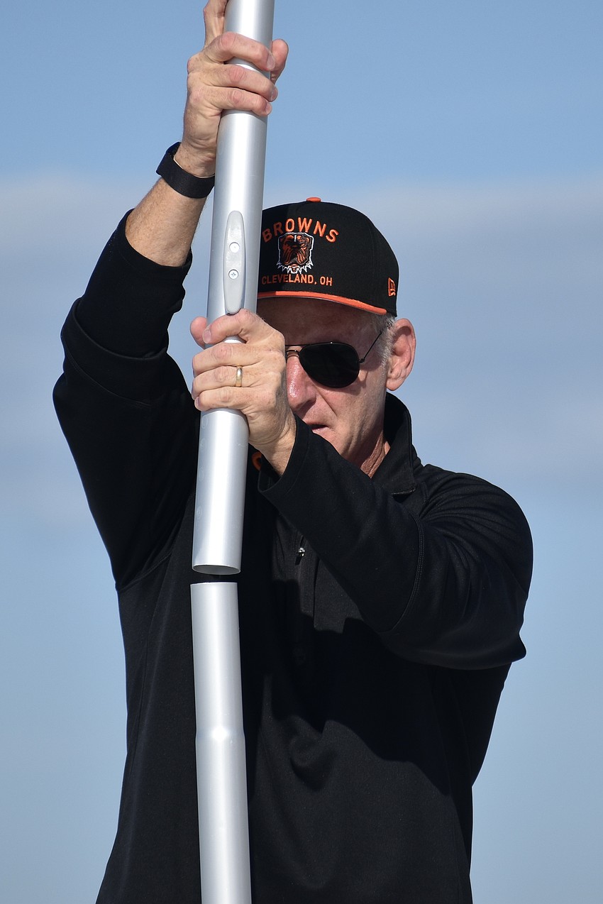 Thomas Modly installs a flagpole on the pier.