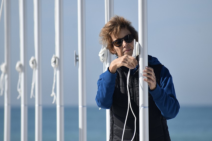 Robyn Modly helps finish the installation of the flagpoles.