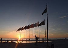 Thomas Modly adjusts the flagpoles as the sun sets.