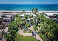 Palm trees and a white sand beach provide a classic tropical setting.