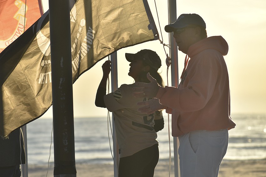 Maria Guardado-Villagran raises the Army flag, standing beside John King, who raised the flag for prisoners of war and those missing in action.