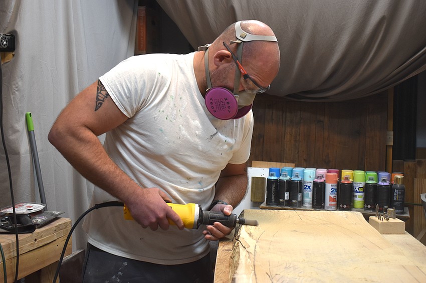 Whit Wesenberg uses his garage as a workshop to carve the designs in the wood for Humu's Island Treasures.