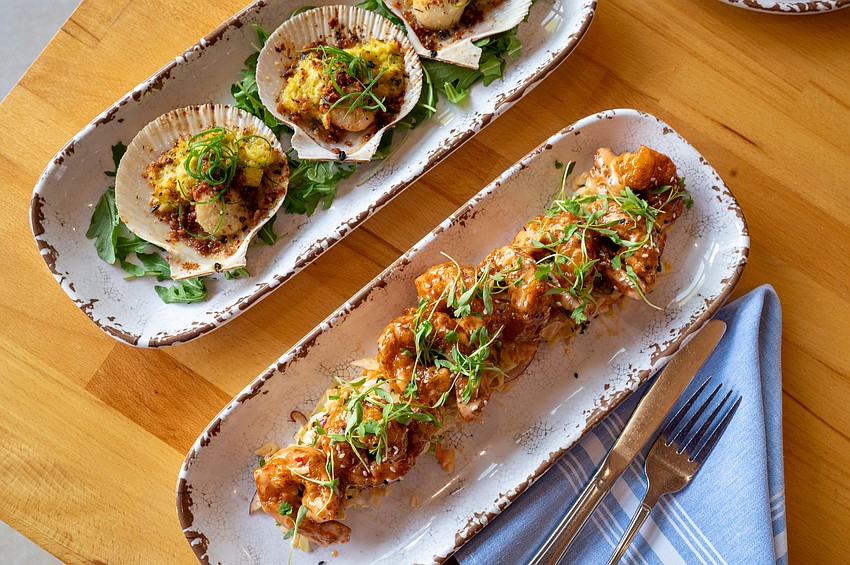 A duo of favorites: sweet and spicy shrimp alongside the crab and corn-baked scallops — coastal comfort with refined technique.