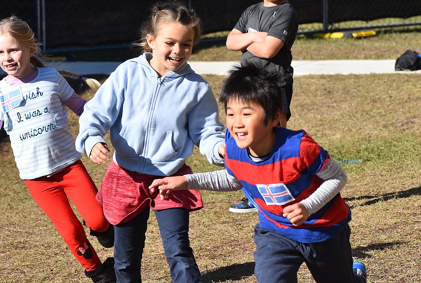 Second graders Kaitlyn Keech, Kaylie Field and Spencer Zhang play a game of Olympic Torch & Ring Freeze Tag during the Tara Olympics.