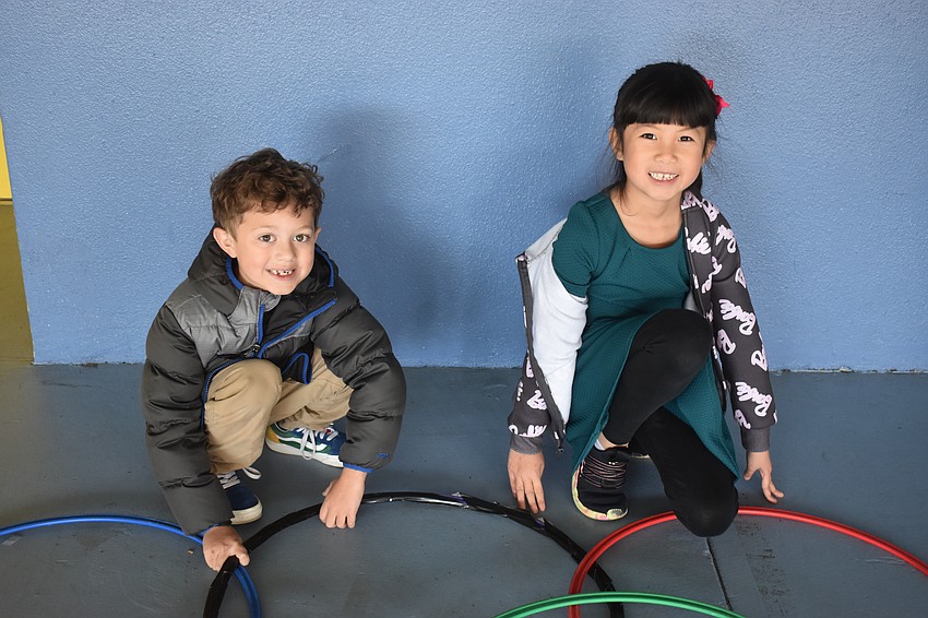 Hunter May and Phoenix Nguyen, first graders at Tara Elementary, take a short break after completing the Olympic Rings Relay.