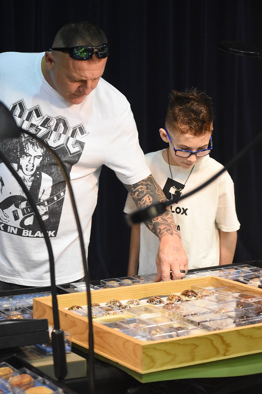 Josh Countryman and his son Rogan Countryman, 12, browse shells.