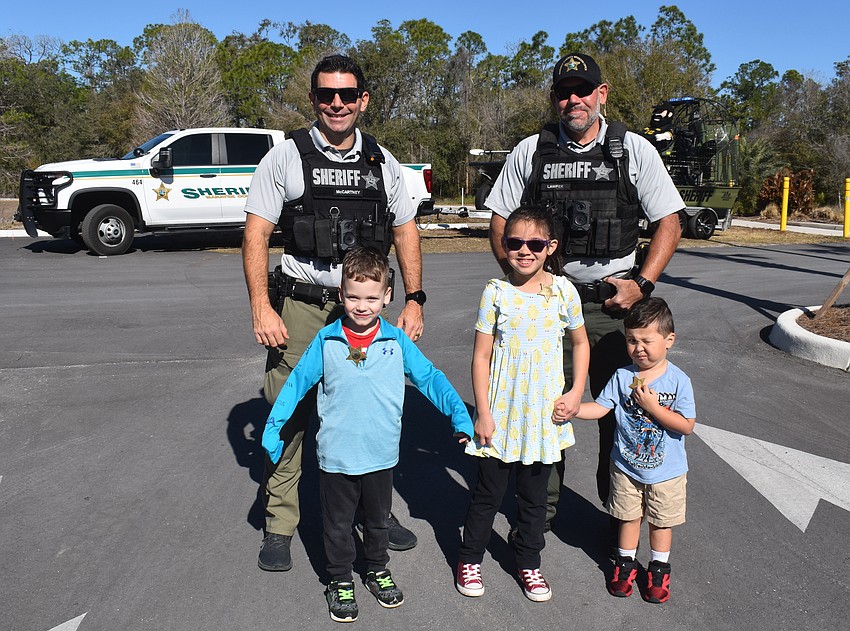 PJ McCartney and Charlie Lawfer, deputies with the Manatee County Sheriff's Office, pose for a photo with Oliver Tretolo, Audrey Malinosky and Roman Malinosky.