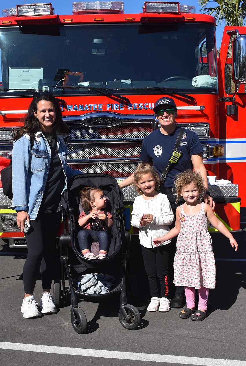 Lakewood Ranch's Whitney Matijevich and her daughters Monroe, Winona and Cecelia are eager to check out the East Manatee Fire Rescue firetruck with the help of probationary firefighter Justine McNaughton.