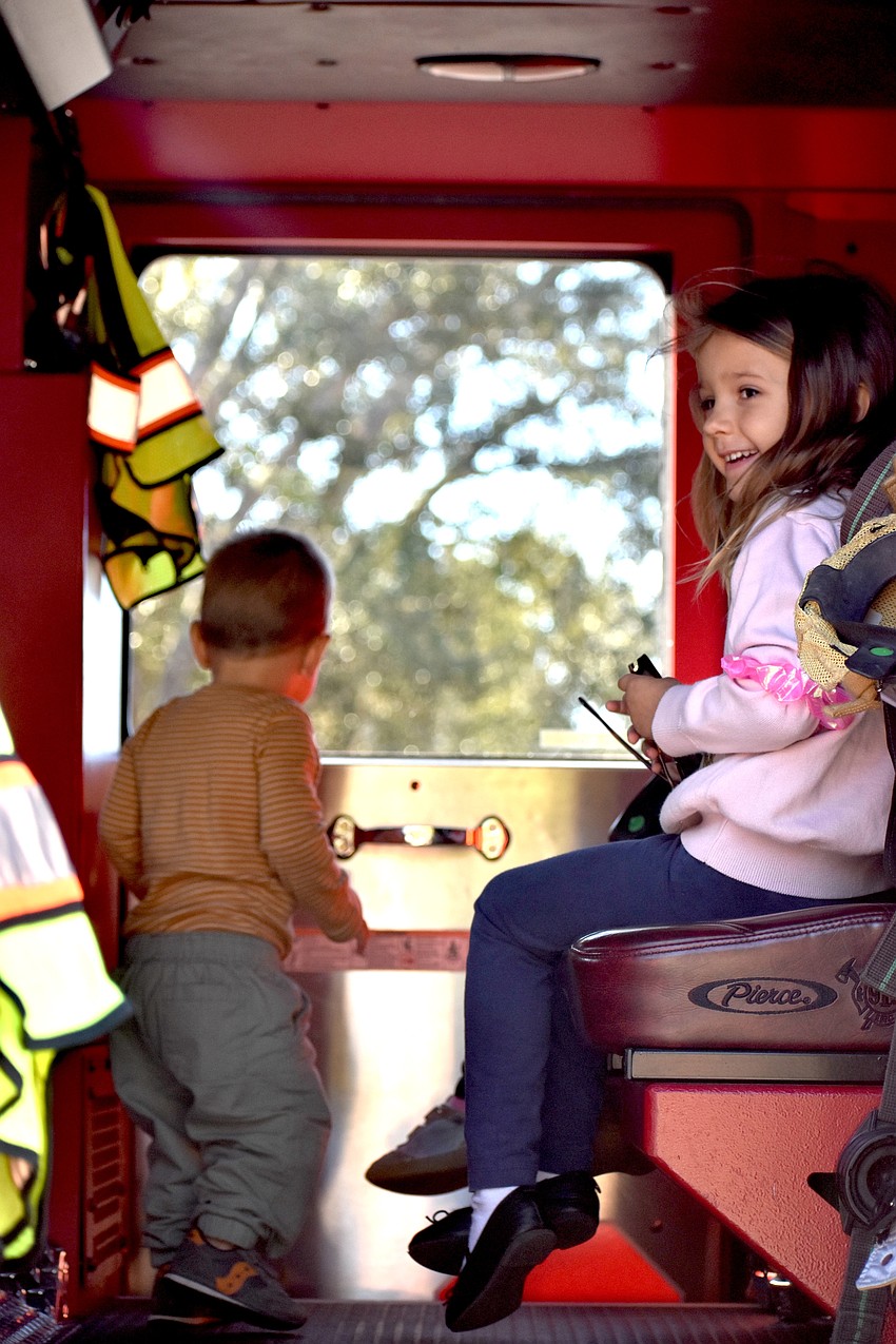 Lakehouse Cove's 16-month-old Hunter Colon looks out the window of the East County Fire Rescue firetruck while 5-year-old Charlotte McCulley sits inside.