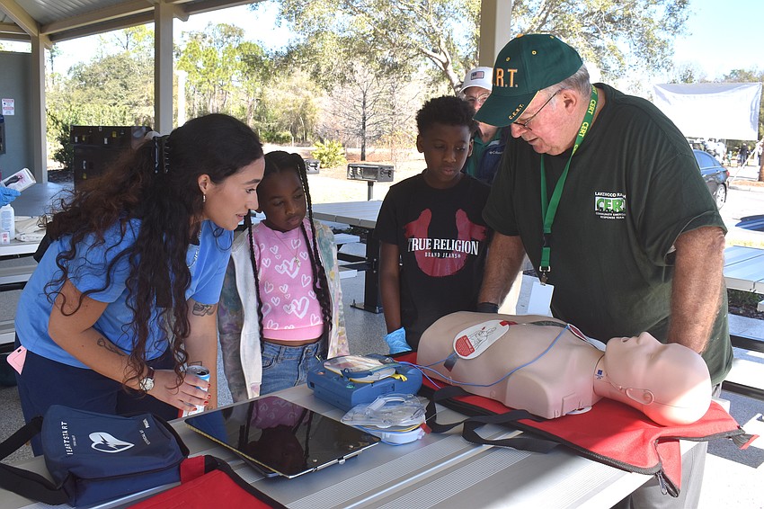 Sapphira Weese, Jade Hooks and Jamari Hooks learn how to do CPR from Pat Knowles. Knowles has been a CERT volunteer for 12 years.