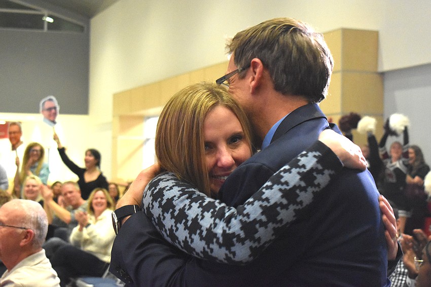 Brooke Dawson, Clifford Dawson's wife since 2017, gives him a hug right after his name was announced as the 2026 Educator of the Year.