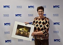 Conference Chair Katherine De Young shows off a winning image. She created the photo using mannequin heads. It was featured in the 2019 "Embracing our Differences" exhibit in Sarasota.