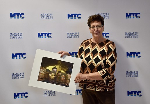 Conference Chair Katherine De Young shows off a winning image. She created the photo using mannequin heads. It was featured in the 2019 "Embracing our Differences" exhibit in Sarasota.
